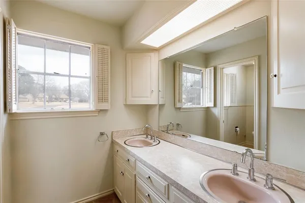 a bathroom with a granite countertop sink window and a mirror