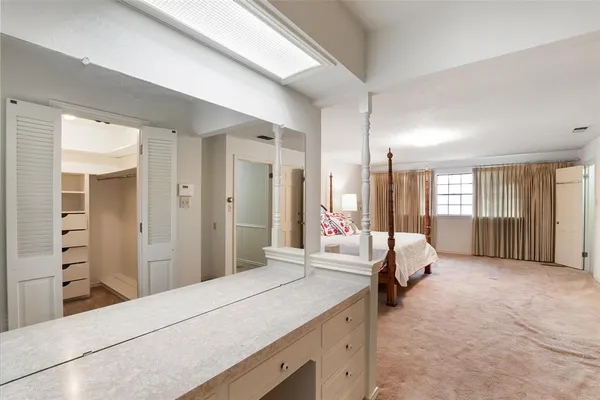 a spacious bedroom with a large bed and a dresser