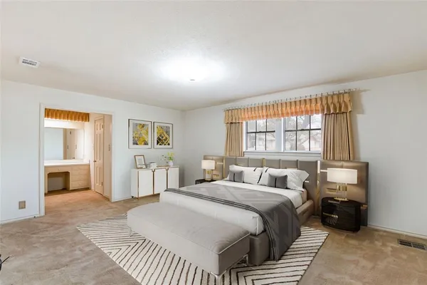 a bedroom with a bed and a large window with chair