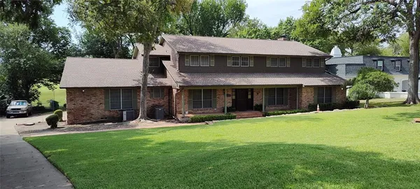 a front view of a house with a yard and trees