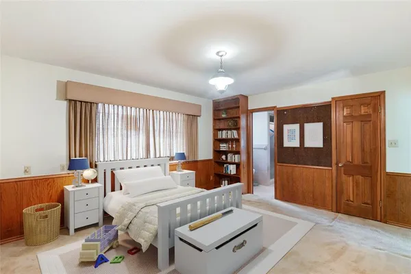 a bedroom with furniture and large window