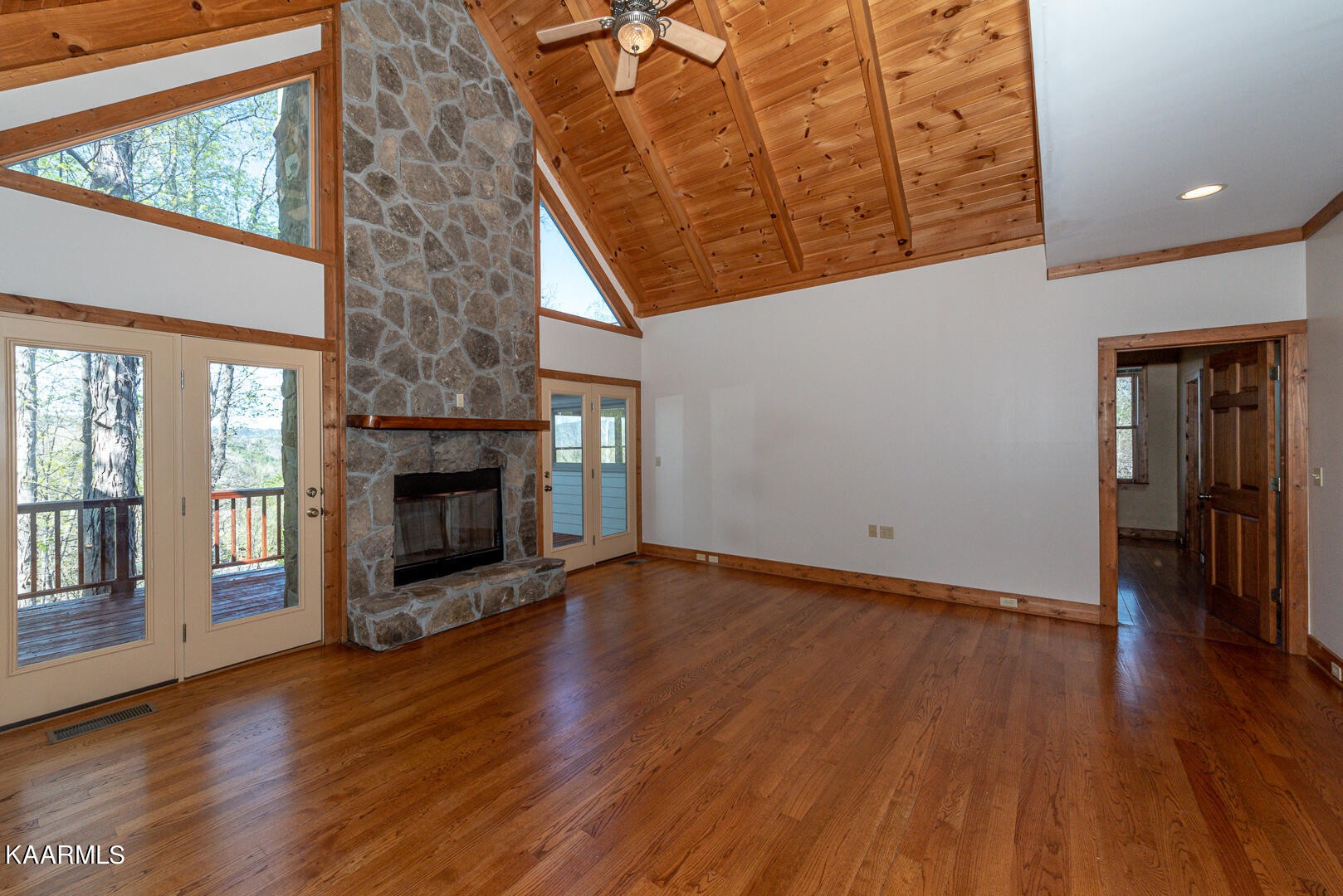 444 Laurel Road Townsend, TN 37882 - Photo 11 of 55 an empty room with wooden floor fireplace and windows