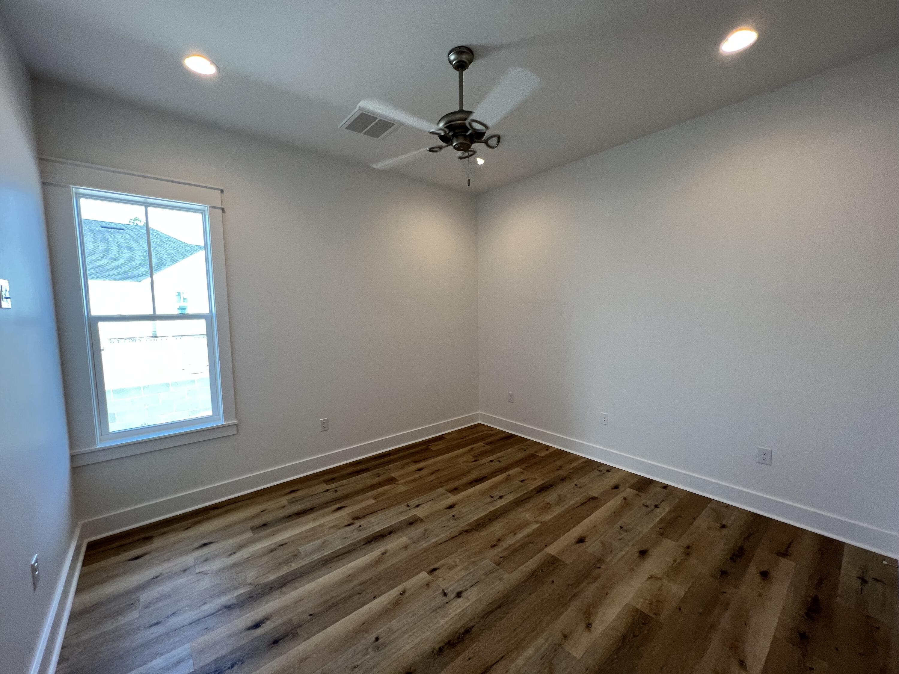 108 Sidecamp Road Watersound, FL 32461 - Photo 19 of 36 an empty room with a chandelier fan and wooden floor