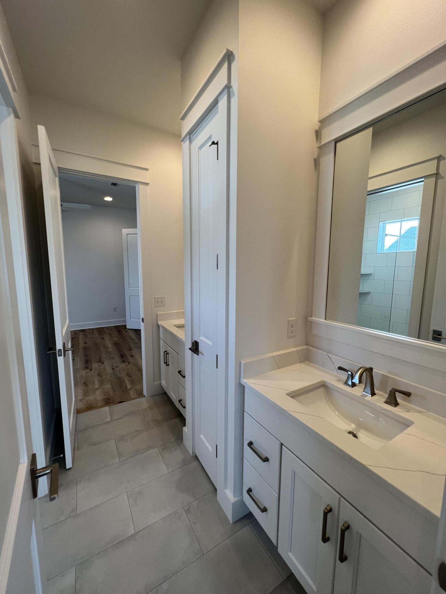 108 Sidecamp Road Watersound, FL 32461 - Photo 20 of 36 a bathroom with a double vanity sink and mirror
