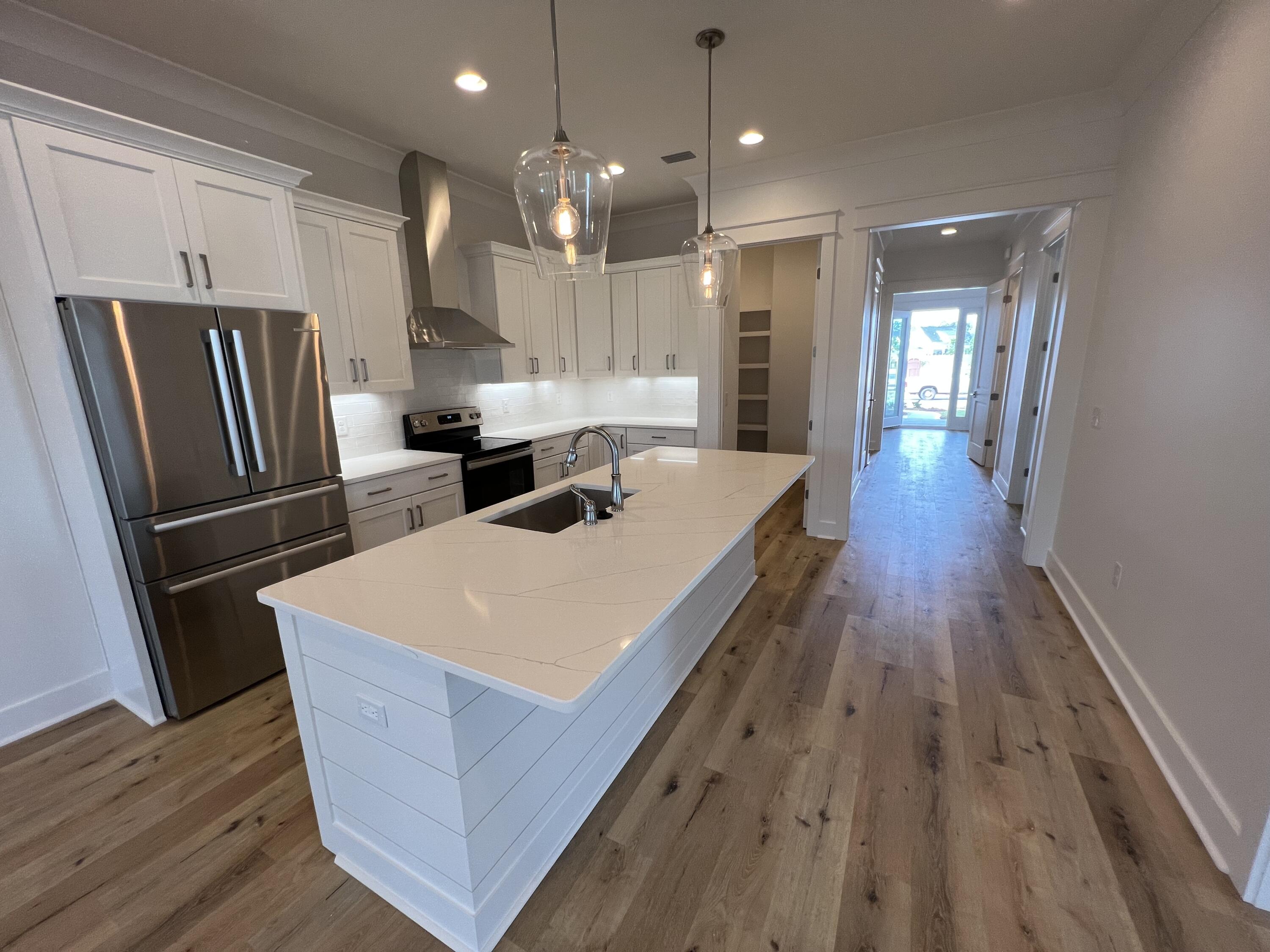 108 Sidecamp Road Watersound, FL 32461 - Photo 6 of 36 a kitchen with stainless steel appliances a refrigerator a sink dishwasher and a stove with wooden floor
