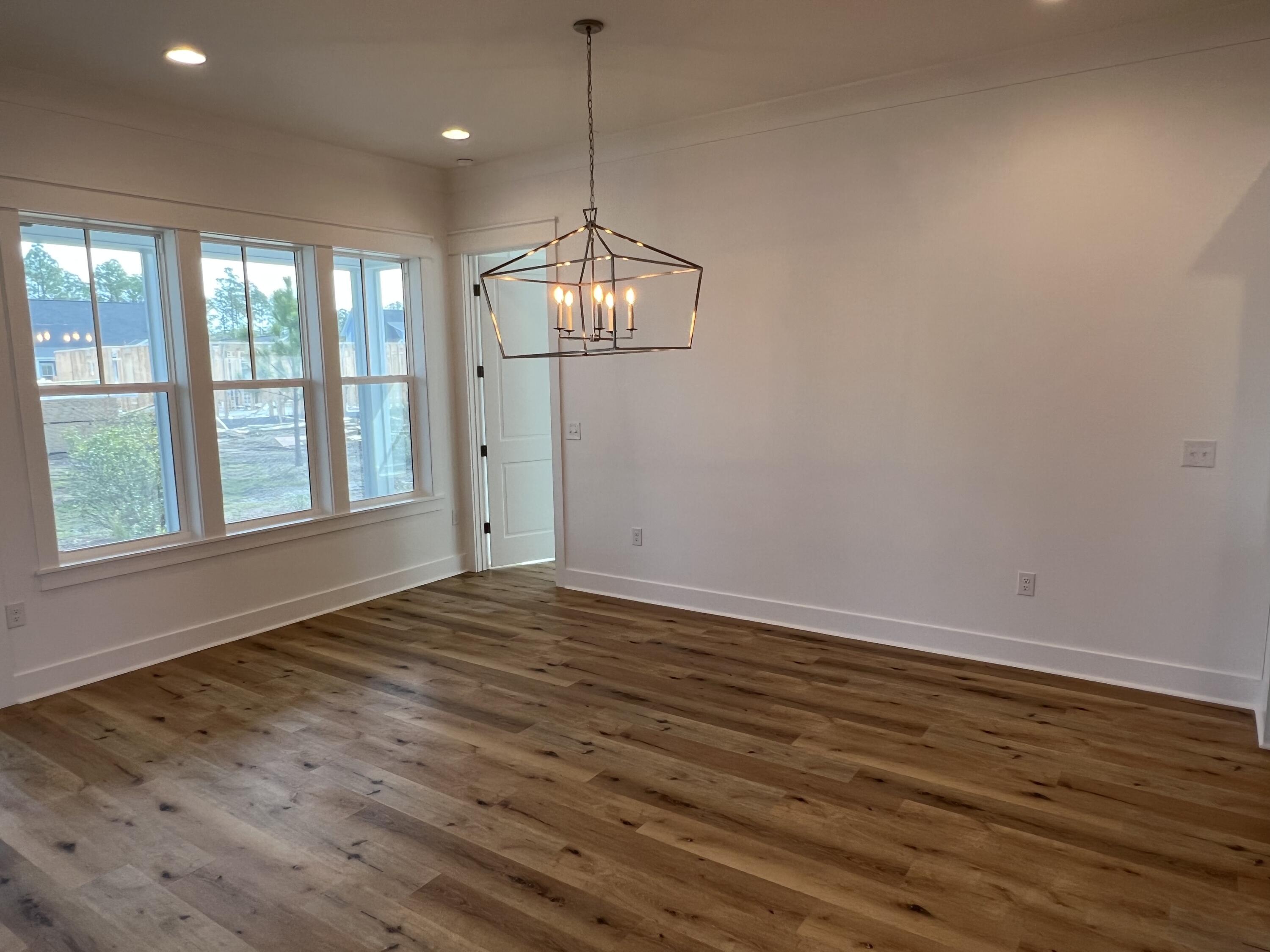 108 Sidecamp Road Watersound, FL 32461 - Photo 10 of 36 a view of an empty room with wooden floor and a window
