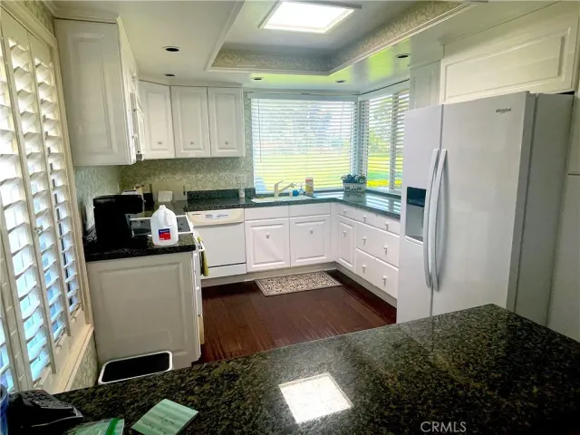 a kitchen with stainless steel appliances a refrigerator sink and white cabinets