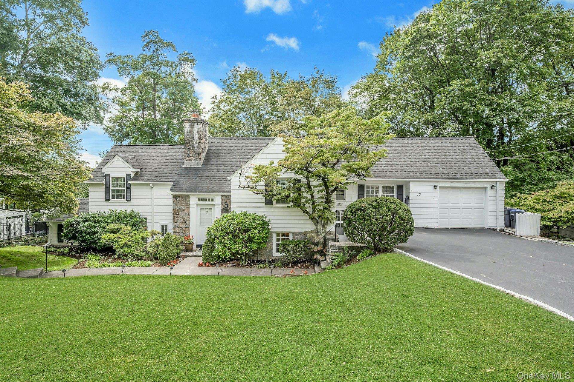 13 Barksdale Road White Plains, NY 10607 - Photo 1 of 1 View of front of home with asphalt driveway, roof with shingles, an attached garage, a front yard, and a chimney