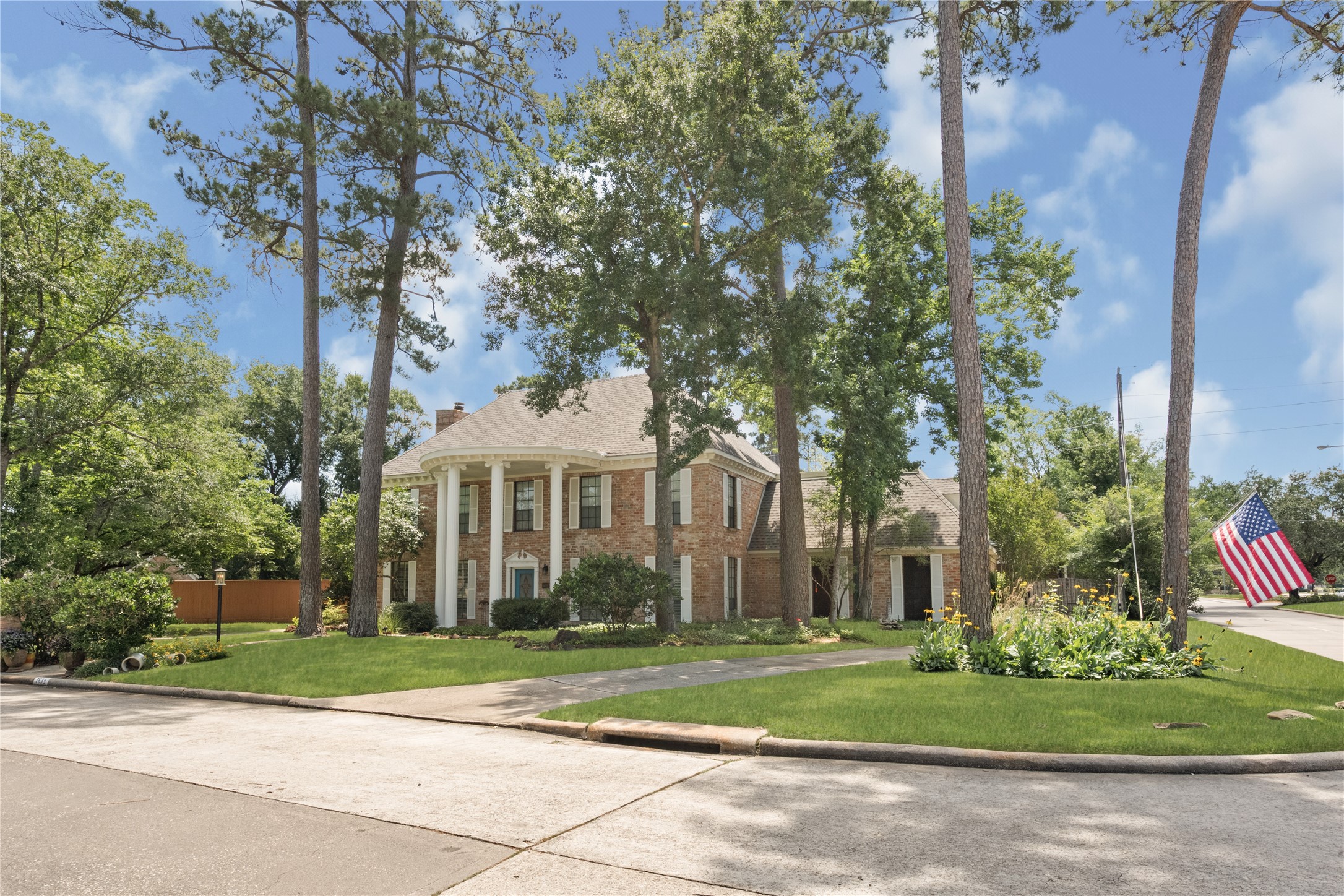 a front view of a house with a yard and trees