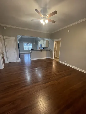 a kitchen with stainless steel appliances granite countertop a sink a stove a microwave a refrigerator a sink and dishwasher with wooden floor