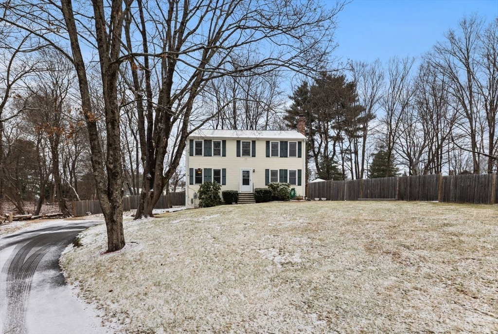 a front view of a house with a yard and trees