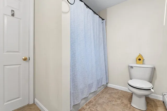 a white toilet sitting next to a shower curtain