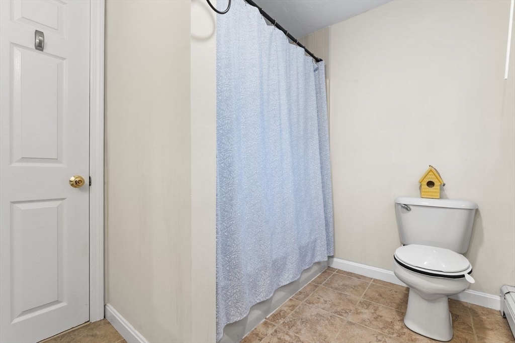 13 Plain Street Upton, MA 01568 - Photo 16 of 27 a white toilet sitting next to a shower curtain