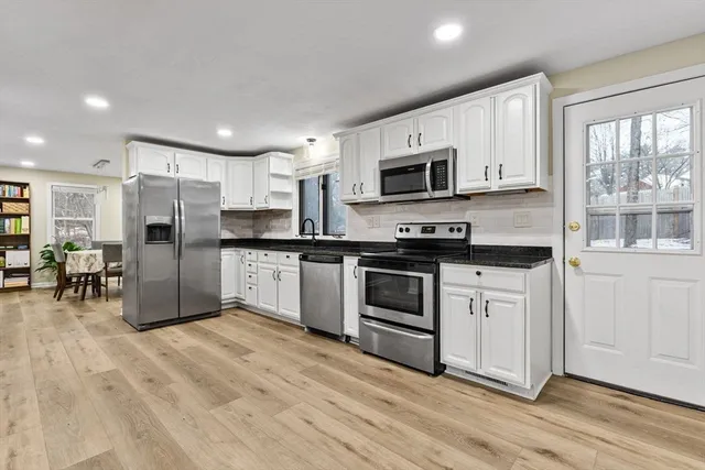 a kitchen with granite countertop a refrigerator and a stove top oven