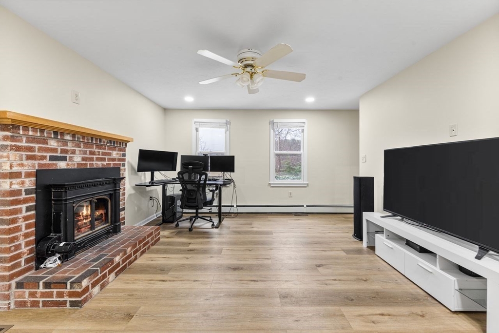 13 Plain Street Upton, MA 01568 - Photo 9 of 27 a living room with furniture flat screen tv and a fireplace