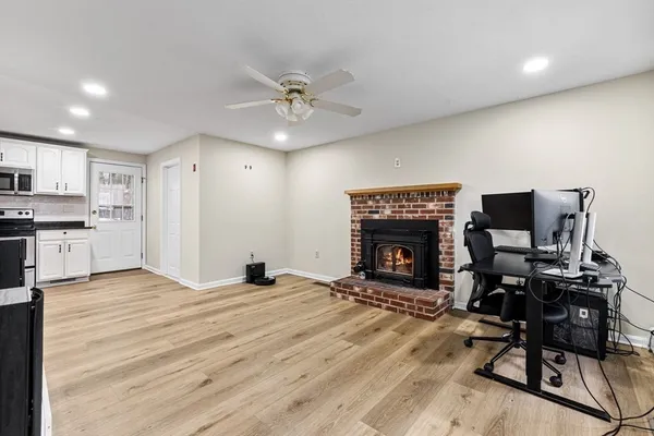 a view of a livingroom with a fireplace and workspace