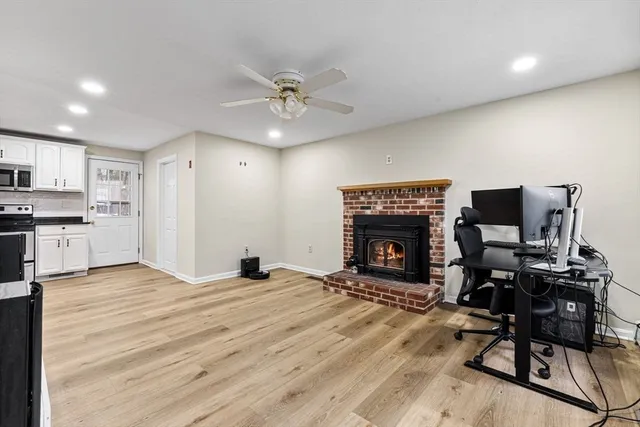 a view of a livingroom with a fireplace and workspace