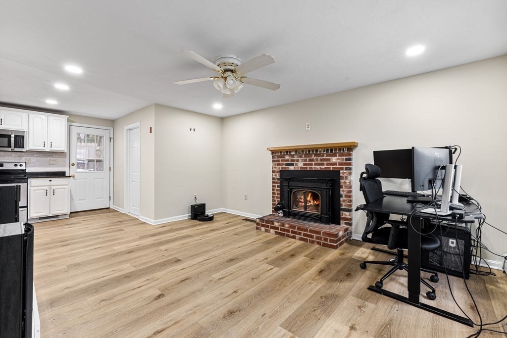 13 Plain Street Upton, MA 01568 - Photo 10 of 27 a view of a livingroom with a fireplace and workspace