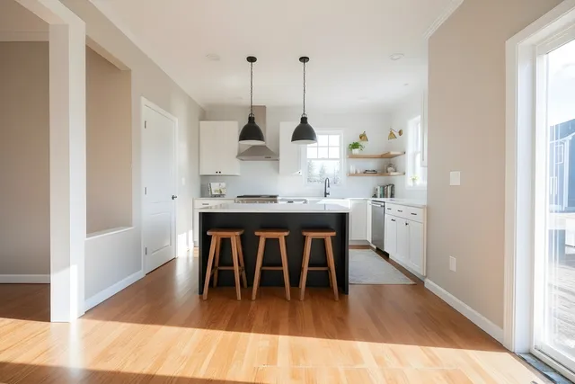 a dining room with kitchen island stainless steel appliances kitchen island a table and chairs in it