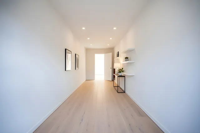 a view of a hallway with wooden floor and a cabinet