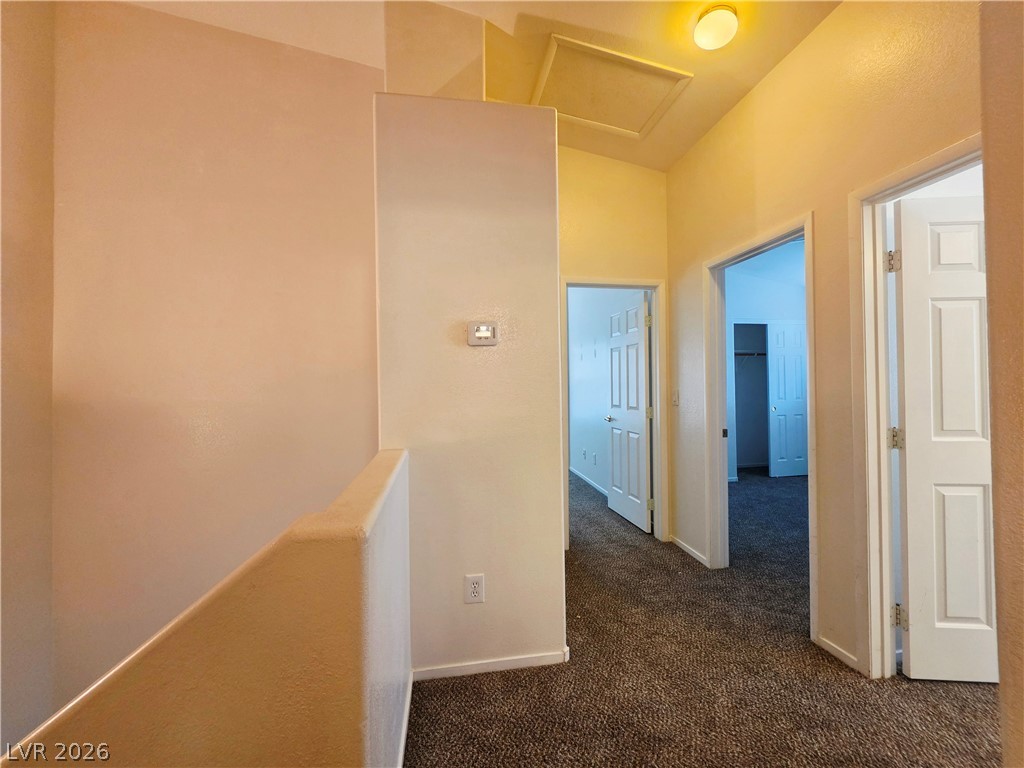 1571 Rusty Ridge Lane Henderson, NV 89002 - Photo 13 of 26 A well-lit hallway with multiple doorways offers a welcoming transition between living spaces.