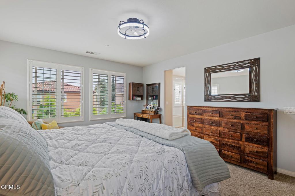652 Xanadu Way Oxnard, CA 93036 - Photo 21 of 40 a bedroom with a bed and a chandelier