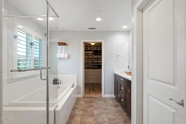 a bathroom with a double vanity sink a mirror and a bathtub