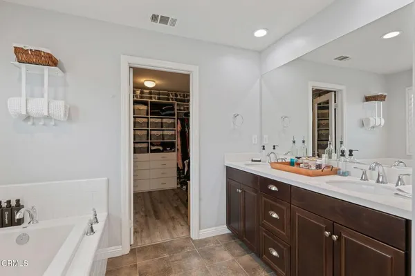 a bathroom with a tub a sink and a large mirror