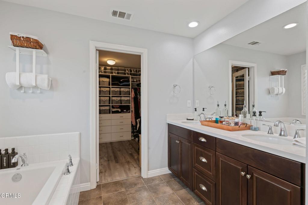 652 Xanadu Way Oxnard, CA 93036 - Photo 23 of 40 a bathroom with a double vanity sink a mirror and a bathtub