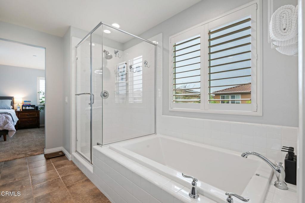 652 Xanadu Way Oxnard, CA 93036 - Photo 24 of 40 a bathroom with a tub a sink and a large mirror