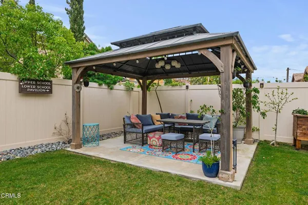 a view of a house with backyard and sitting area