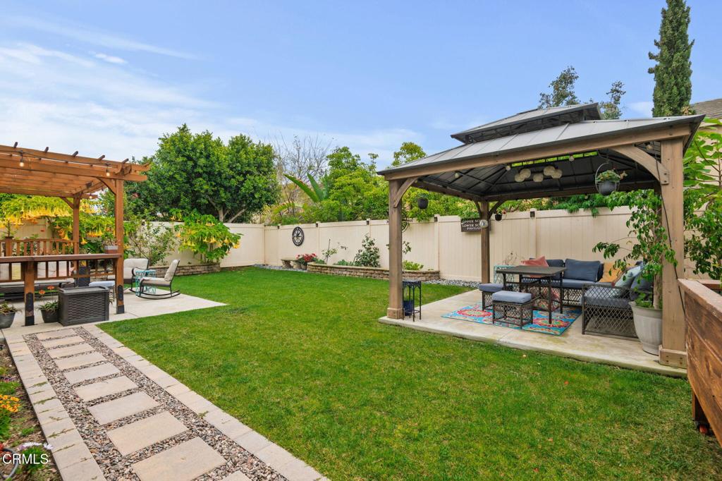652 Xanadu Way Oxnard, CA 93036 - Photo 35 of 40 a view of a patio with a table and chairs under an umbrella with a small yard