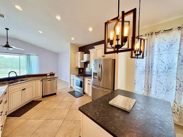 a kitchen with stainless steel appliances granite countertop a sink refrigerator and microwave