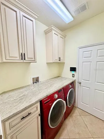 a utility room with cabinets washer and dryer