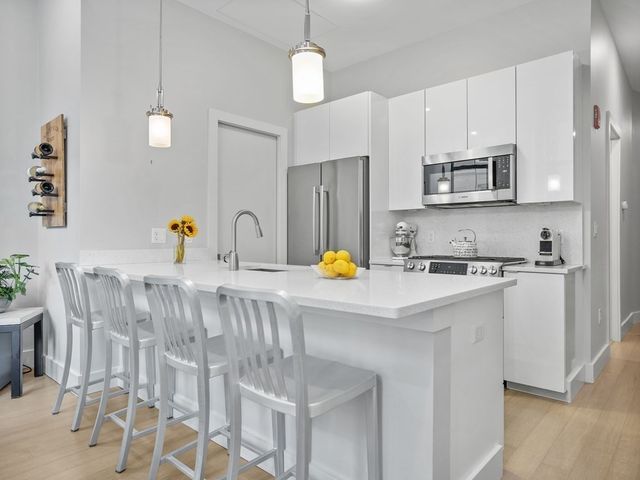 a kitchen with stainless steel appliances a sink refrigerator and microwave