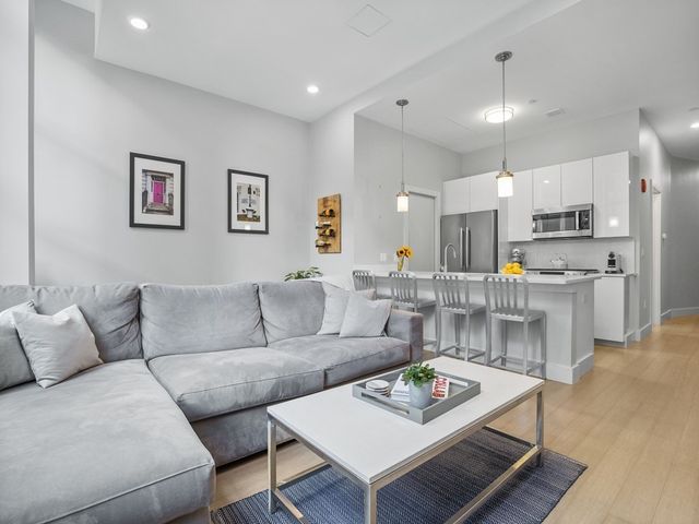 a living room with furniture and kitchen view
