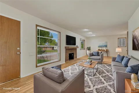 a living room with furniture a fireplace and a flat screen tv