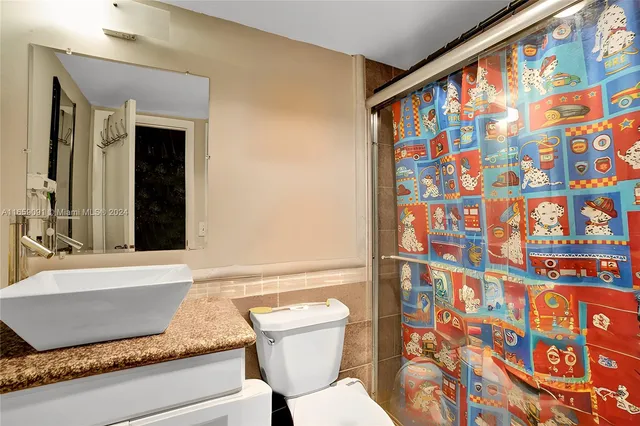 a bathroom with a granite countertop sink and a bathtub