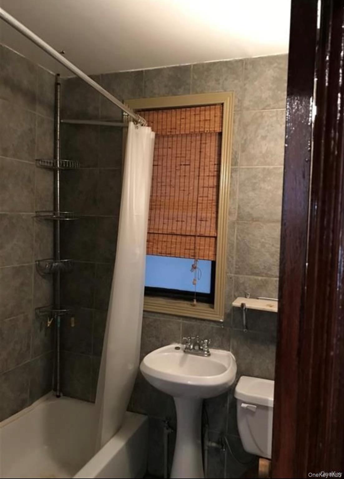 740 South Oak Drive Bronx, NY 10467 - Photo 3 of 4 a bathroom with a sink toilet and shower