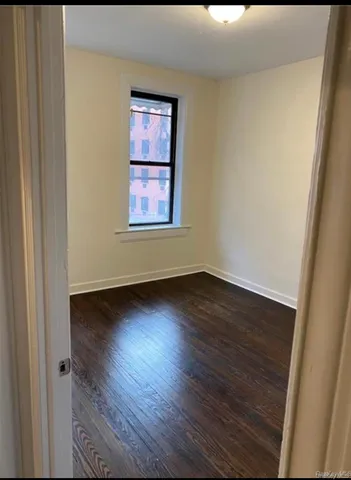 a view of a room that has wooden floor and cabinets in it