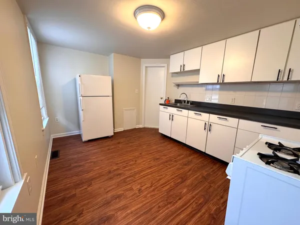 a kitchen with granite countertop a sink a stove and refrigerator