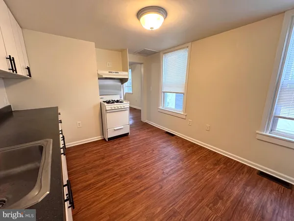 a kitchen with wooden floors and appliances