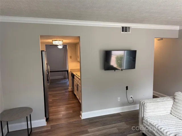 a view of a hallway with wooden floor and a mirror