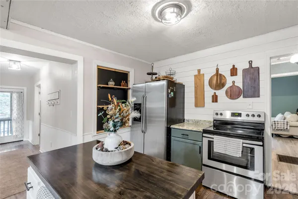 a kitchen with stainless steel appliances kitchen island granite countertop a stove and cabinets