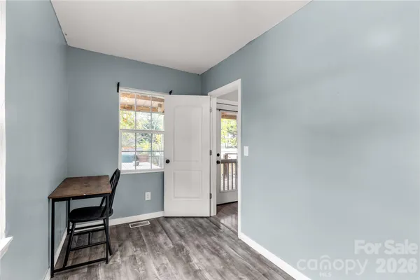 a workspace room with wooden floor and windows