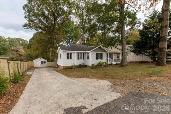 a front view of a house with a yard and trees