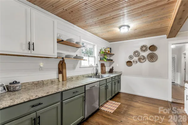 a kitchen with granite countertop a sink a stove and cabinets