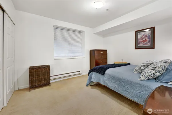 a bedroom with a bed and a lamp on dresser