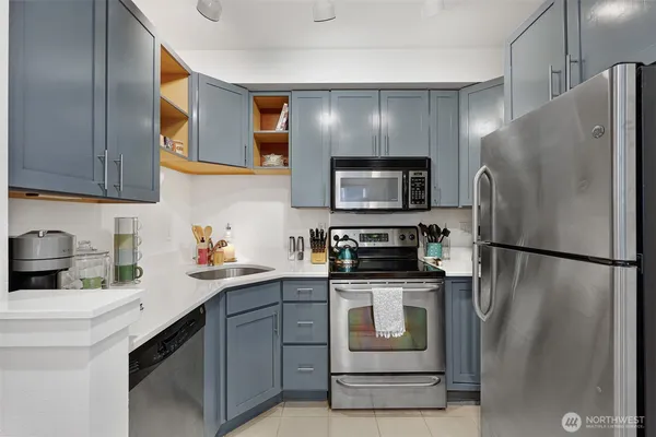 a kitchen with a sink a refrigerator a microwave and cabinets