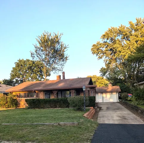 a view of a big house with a big yard and potted plants